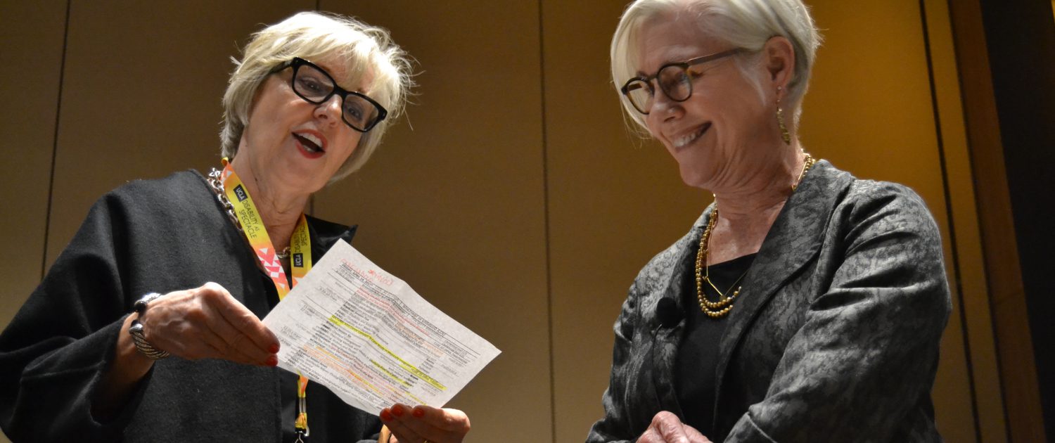 Alice Wexler reviewing the conference schedule with Rosemarie Garland-Thomson